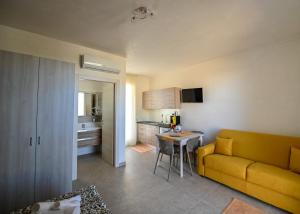 un soggiorno con divano giallo e una cucina di ARIA D'ORIENTE a Uggiano la Chiesa