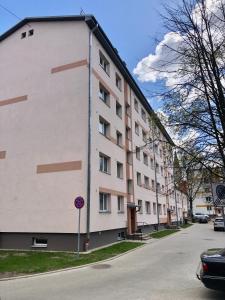 a large white building on the side of a street at Smart Stay Apartment in Valmiera