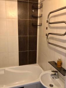 een badkamer met een wastafel en een bad bij Smart Stay Apartment in Valmiera