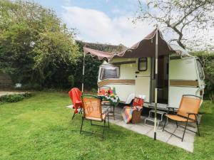 ein Wohnwagen mit Tisch und Stühlen in einem Hof in der Unterkunft Norden House in Dorchester