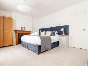 a bedroom with a large bed and a fireplace at Mazey Cottage in Penzance