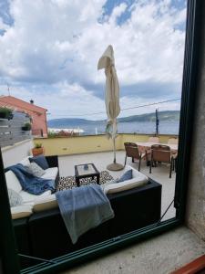 瓦倫的住宿－Palac - Giordano，阳台配有沙发和遮阳伞。