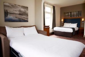 a hotel room with two beds and a window at White Rabbit by Chef & Brewer Collection in Lyndhurst