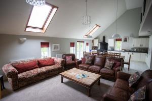 un soggiorno con divani e un tavolo di Corporate and Business Events and Away Days - Wellstone Cottages - Sleeps 24 a Llanfyrnach