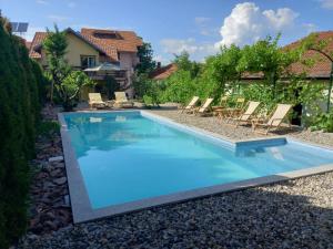 a swimming pool with chairs and a house at Apartmani ,,Vasa ,, 2 in Soko Banja
