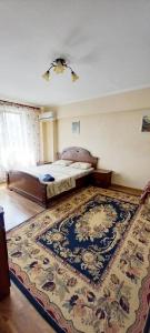 1 dormitorio con cama y alfombra grande en Одна комнатная квартира в центре en Shymkent