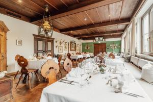 a large dining room with white tables and chairs at Hotel Bruggwirt in Sankt Johann in Tirol