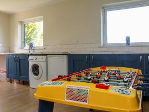 uma cozinha com uma mesa de jogos no meio em Ash Tree Cottage em Holsworthy