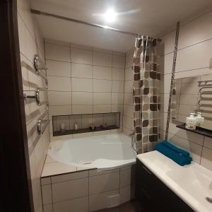 a bathroom with a tub and a sink at Jaukus butas Druskininkuose in Druskininkai