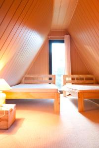 a attic room with two beds and a window at Ferienhaus am See - a55956 in Perlin