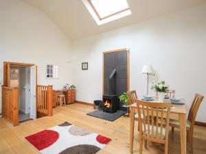 a living room with a table and a fireplace at Lleyn Cottage The Hive in Menai Bridge