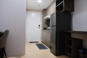 une cuisine avec un réfrigérateur noir et une porte. dans l'établissement Sun Vida Tower Studio Unit Across SM City Cebu, à Cebu