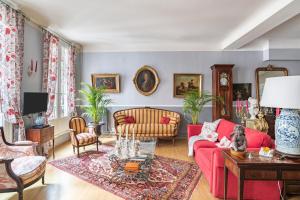 salon z czerwoną kanapą i krzesłami w obiekcie Hôtel des Arceaux w Bajonnie