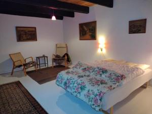 a bedroom with a bed and chairs in a room at Store Lærkegård in Allinge