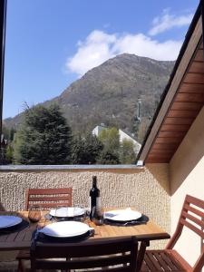 a table with a bottle of wine and a view of a mountain at Saint Lary Ski, rando, thermes, balades et repos ! in Saint-Lary-Soulan