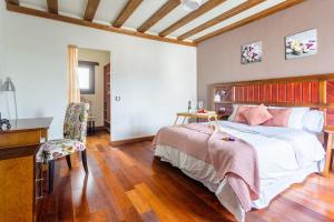 a bedroom with a bed and a desk and a chair at Casa Layka, con maravillosas vistas al mar in La Asomada