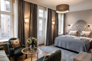 a hotel room with a bed and chairs at Fiftyseven Hotel Copenhagen in Copenhagen