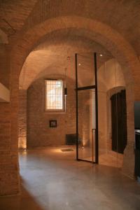 an empty room with a glass door in a brick wall at DesArt sweet Poeta in Perugia