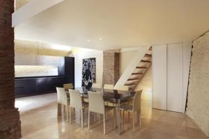 a dining room with a table and chairs and a staircase at DesArt sweet Poeta in Perugia