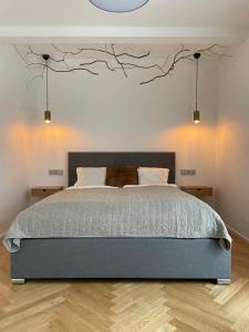 a bedroom with a bed with branches on the wall at HARDY - Cognac & Pension in Valtice
