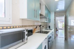 a kitchen with blue cabinets and white counter tops at Montjuic1 in Barcelona