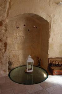 - une lanterne assise sur une table en verre dans une pièce dans l'établissement Il Casale di Maria, à Matera