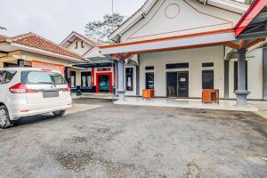 a white van parked in front of a gas station at OYO Homes 91124 Desa Wisata Kaso 