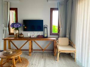 a living room with a desk with a tv and a chair at The Mak Trat in Ko Mak