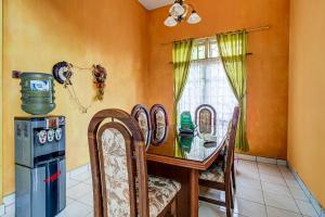 jadalnia ze stołem i krzesłami oraz oknem w obiekcie OYO Homes 91124 Desa Wisata Kaso 