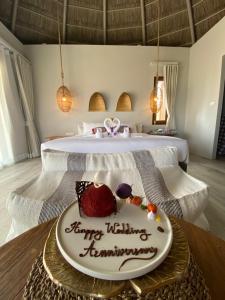 a cake on a table in front of a bed at The Mak Trat in Ko Mak