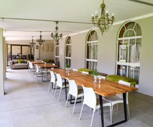 a dining room with a long table and chairs at Scott's Manor Guesthouse Function and Conference Venue in Lichtenburg