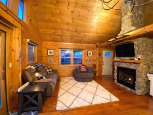 uma sala de estar com lareira num chalé de madeira em Cozy modern log cabin in the White Mountains - AC - granite - less than 10 minutes from Bretton Woods em Carroll