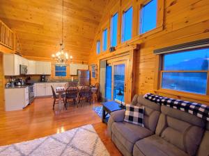 uma sala de estar com um sofá e uma mesa em Cozy modern log cabin in the White Mountains - AC - granite - less than 10 minutes from Bretton Woods em Carroll