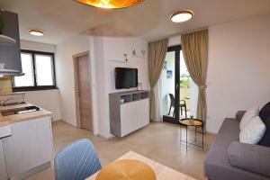 a living room with a couch and a tv at Sole Pula Apartman-near beach in Pula