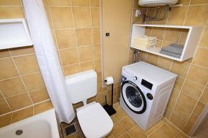 a bathroom with a toilet and a washing machine at Sole Pula Apartman-near beach in Pula