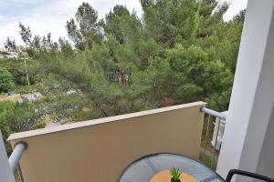 a balcony with a table and a tree at Sole Pula Apartman-near beach in Pula