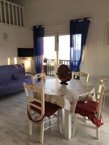 Bados affaccio sul mare في أولبيا: طاولة طعام وكراسي مع طاولة وأريكة
