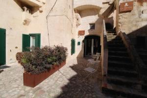 un callejón con escaleras y plantas en un edificio en Il Casale di Maria, en Matera