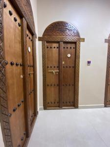 a pair of wooden doors in a room at Nizwa Heritage Inn in Nizwa