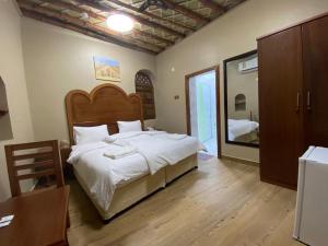 ein Schlafzimmer mit einem großen Bett und einem Spiegel in der Unterkunft Nizwa Heritage Inn in Nizwa
