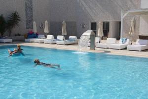 two people swimming in a large swimming pool at Silver Sands Beach Hotel in Protaras