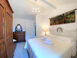 een slaapkamer met een bed met witte lakens en een kroonluchter bij CASA ARIANNA in Siena