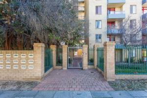 una valla con una puerta delante de un edificio en Sky High on Arundel - central Fremantle apartment, en Fremantle