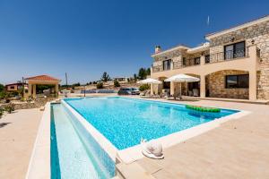 a large swimming pool in front of a house at SunShine Villa Paphos in Nicosia