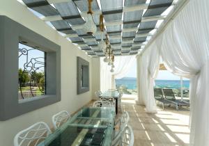 a dining room with a glass table and a view of the ocean at CHARM BEACH HOTEL in Akyarlar