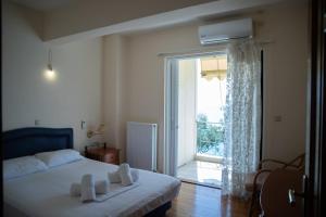 a bedroom with a bed and a large window at Palaiohora Avias Apartments 2 in Avia