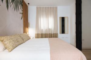 En eller flere senge i et værelse på Magno Apartments Azafrán