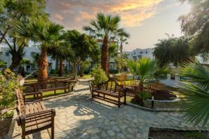 a row of benches in a park with palm trees at CHARM BEACH HOTEL in Akyarlar