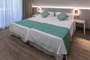 a bed room with a white bedspread and pillows at 4R Casablanca Playa in Salou
