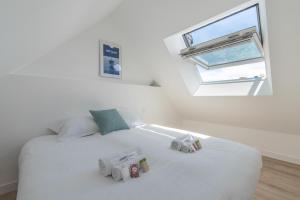 a bedroom with a white bed with two toy cars on it at Charmant appartement proche centre-ville plage in Saint-Nazaire